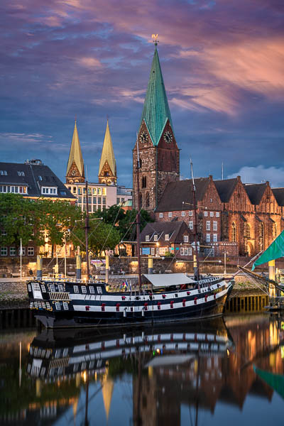 Evening in the historic town of Bremen, Germany with old sailing ship on Weser river by Michael Abid