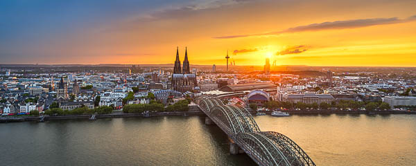 Panoramablick auf die Kölner Skyline bei Sonnenuntergang mit dem Dom und der Hohenzollernbrücke am Rhein in Deutschland von Michael Abid