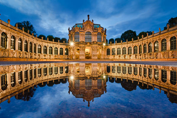 Zwinger in Dresden, Germany at night with reflection in a rain puddle by Michael Abid