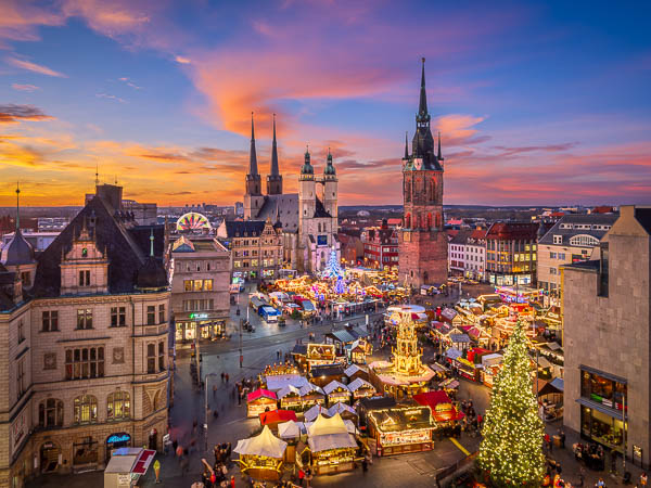 Skyline von Halle (Saale), Deutschland bei Sonnenuntergang mit den berühmten fünf Türmen und dem Weihnachtsmarkt von Michael Abid