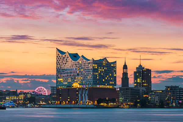 The iconic Elbphilharmonie building and the Michel (St. Michael's church) in Hamburg, Germany during a beautiful sunset by Michael Abid