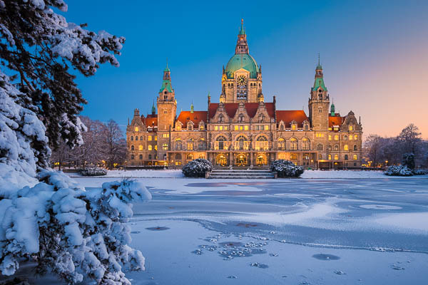 Town Hall of Hannover, Germany in winter with snow and frozen lake by Michael Abid