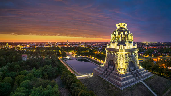 Aerial view of the Völkerschlachtdenkmal (Monument to the Battle of the Nations) at night with the skyline of Leipzig in the background, Saxony, Germany by Michael Abid
