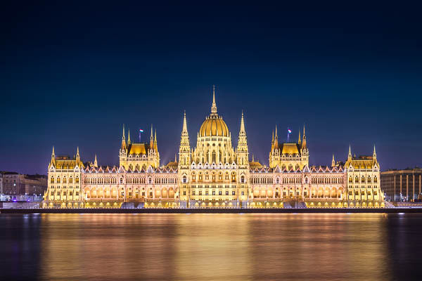 Parliament building in Budapest, Hungary at night with the Danube river in the foreground by Michael Abid