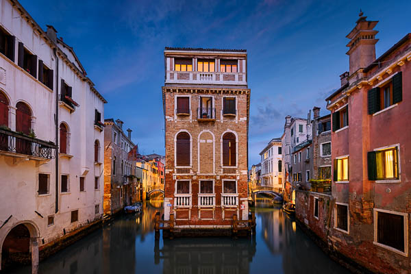 Buildings along a canal in Venice, Italy at night by Michael Abid