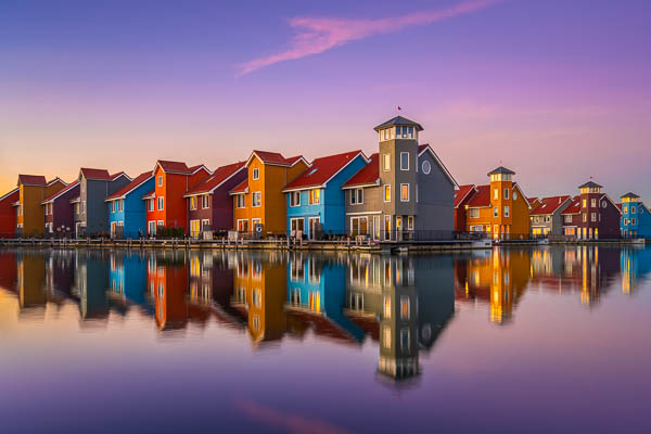 Colorful buildings along the water in Reitdiephaven, Groningen, Netherlands during sunset by Michael Abid