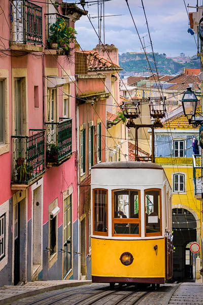 Historic yellow tram in a steep street in Lisbon, Portugal by Michael Abid
