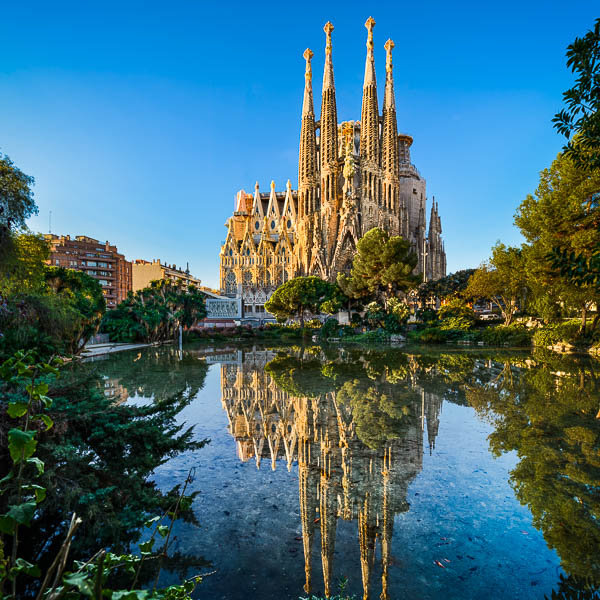 Kathedrale Sagrada Familia in Barcelona, Spanien an einem sonnigen Morgen mit Spiegelung in einem See von Michael Abid