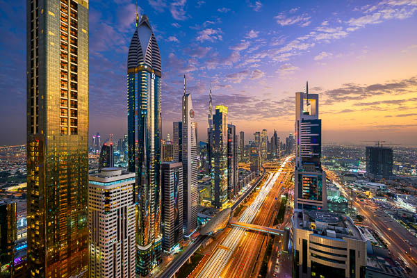 Blick bei Sonnenuntergang auf die Wolkenkratzer entlang der Sheikh Zayed Road in Dubai, UAE von Michael Abid